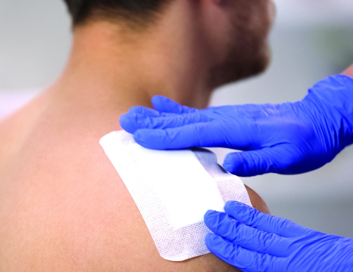 Male patient getting a bandage applied to his shoulder